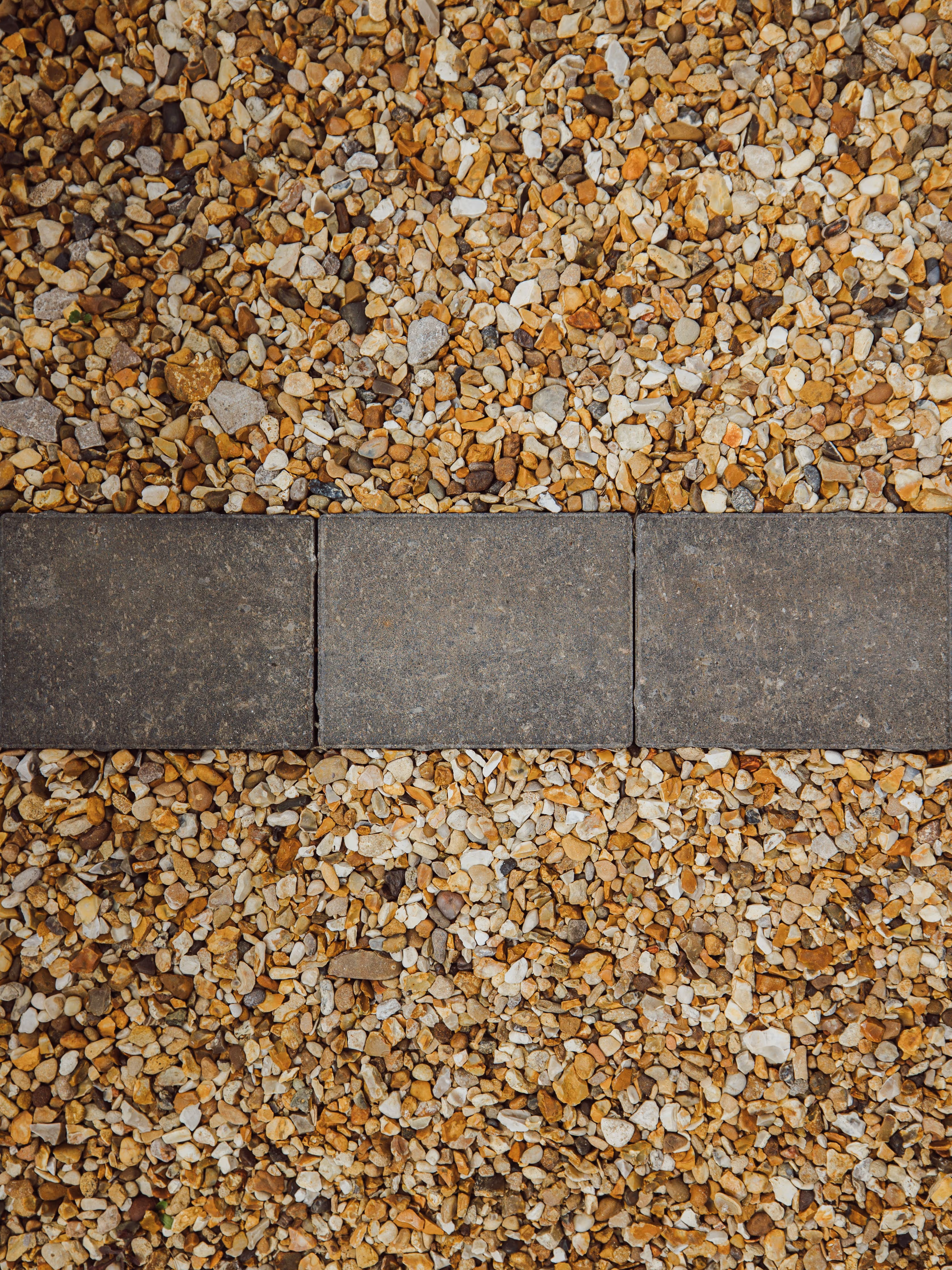 Close up top-down view of gravel and granite effect block paving.