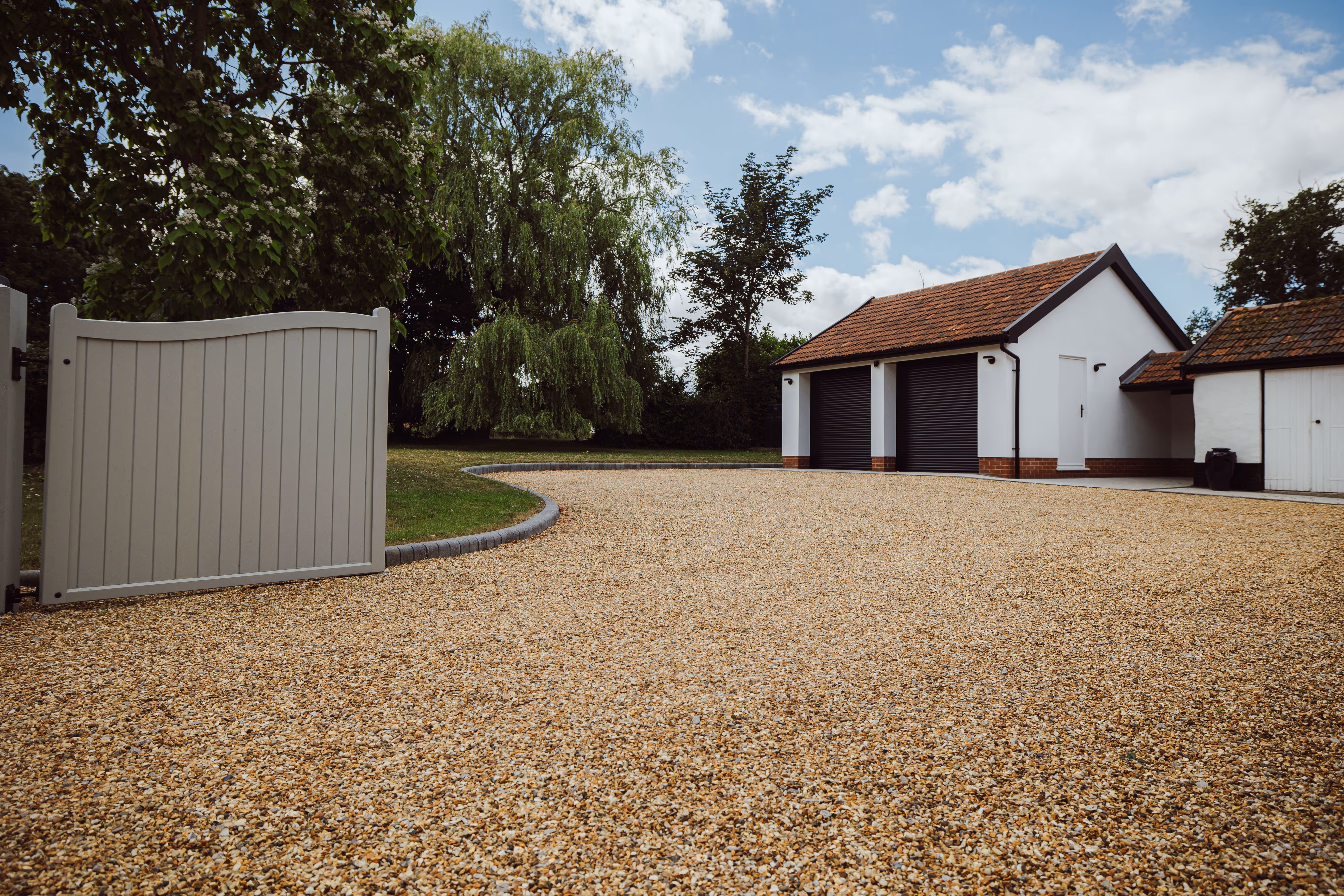 Gravel driveway at Church Cottage, you can see a double garage in the background. 