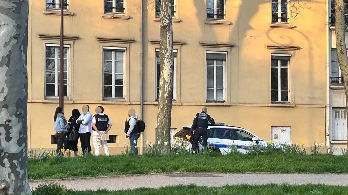 Groupe de personnes discutant avec la police près d'un immeuble.