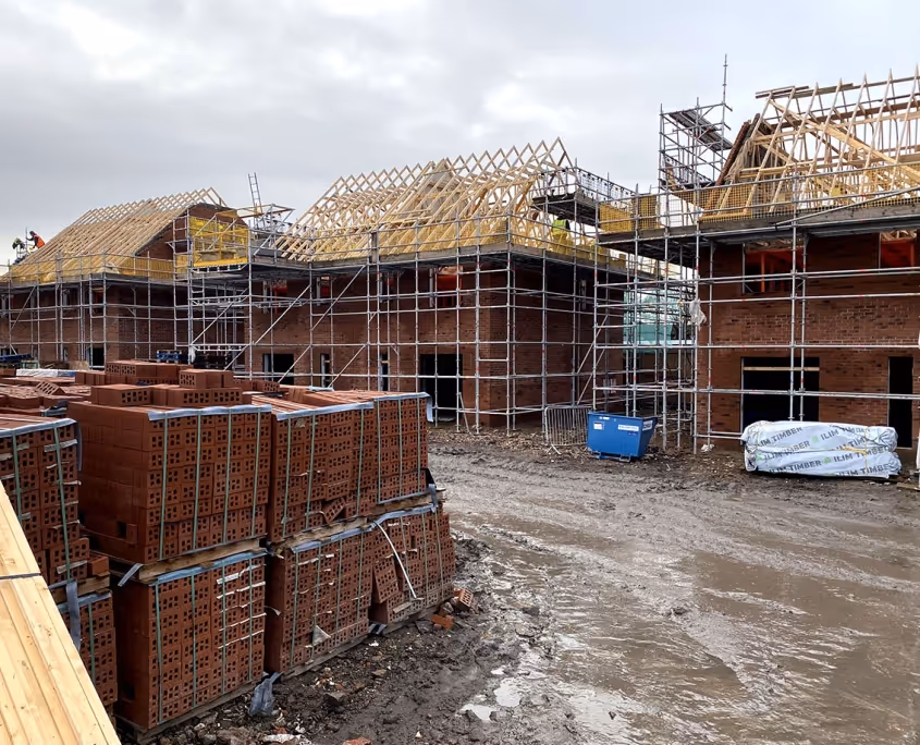 Three new build houses under construction with scaffolding all around each property.