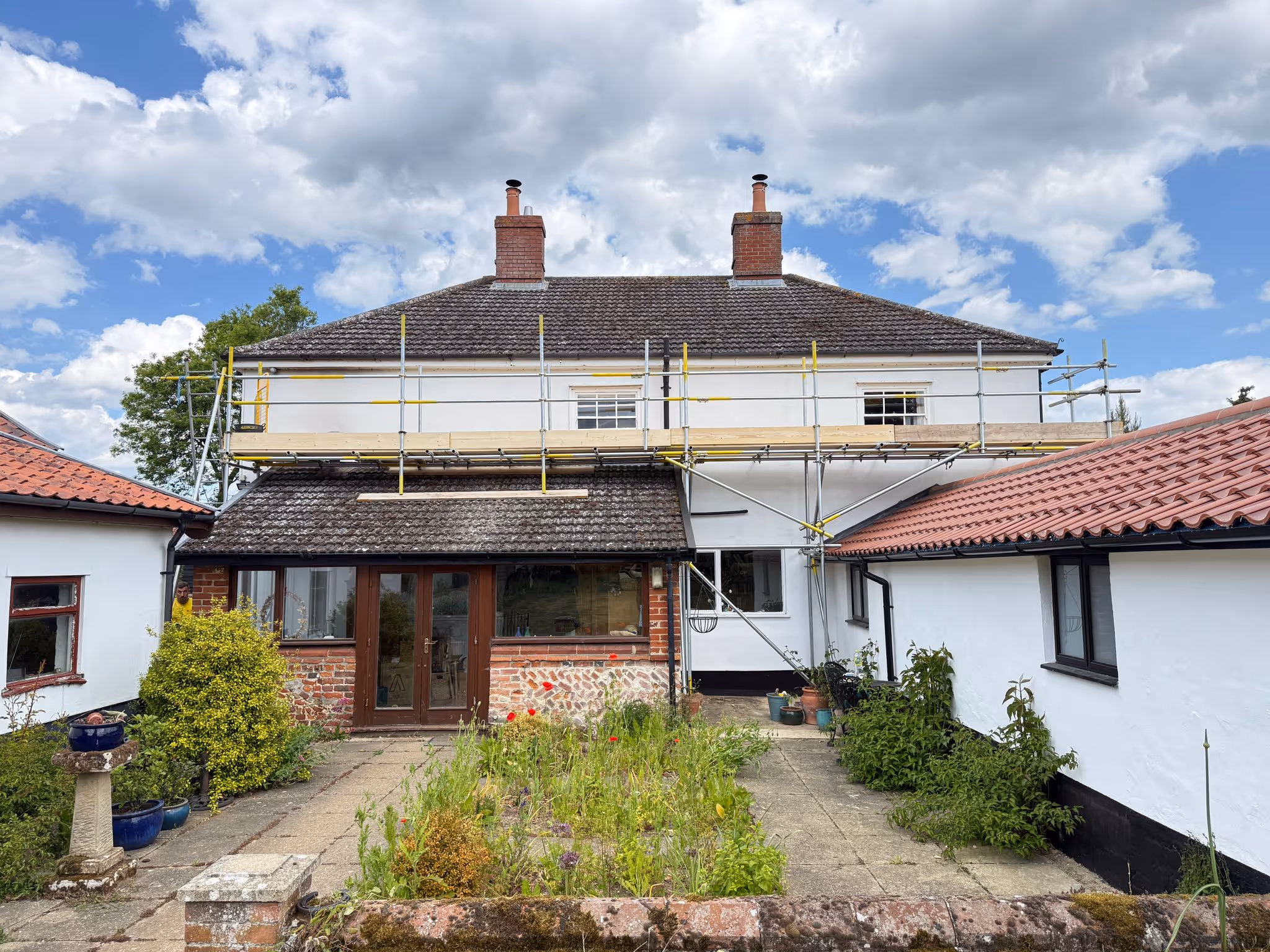 Scaffolding assembled along back of white house .