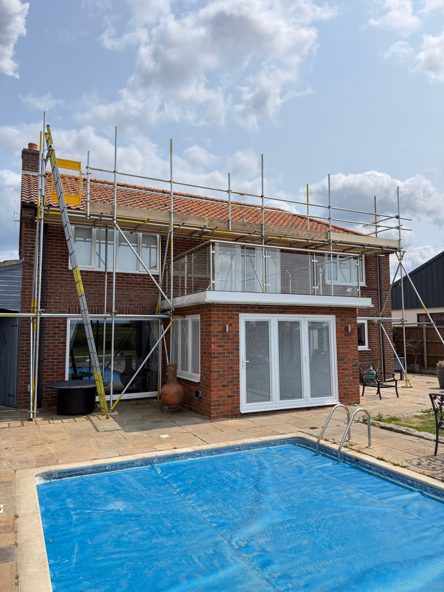 Worker standing on platform of scaffolding.