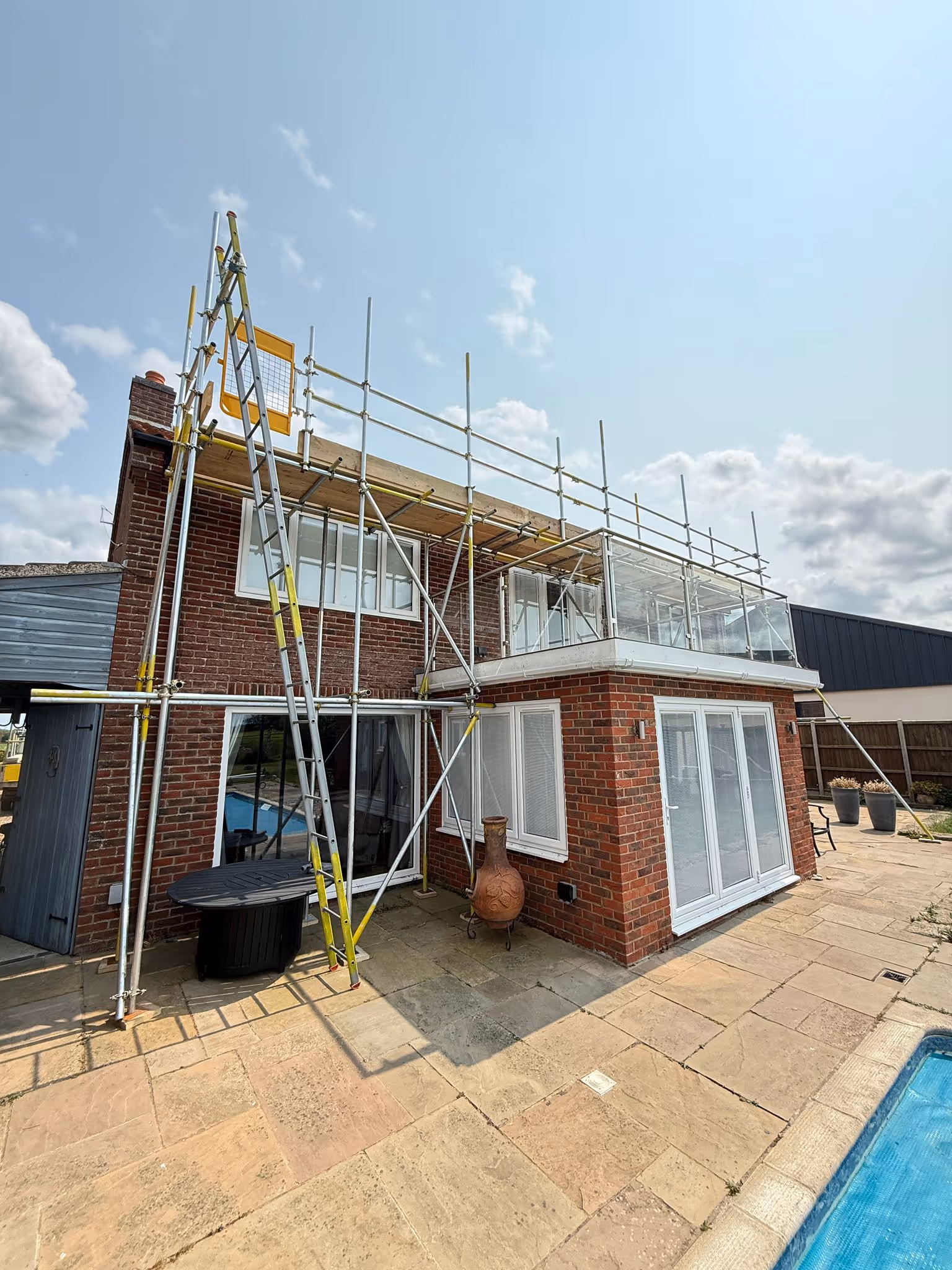 Scaffolding assembled on back of two story house.