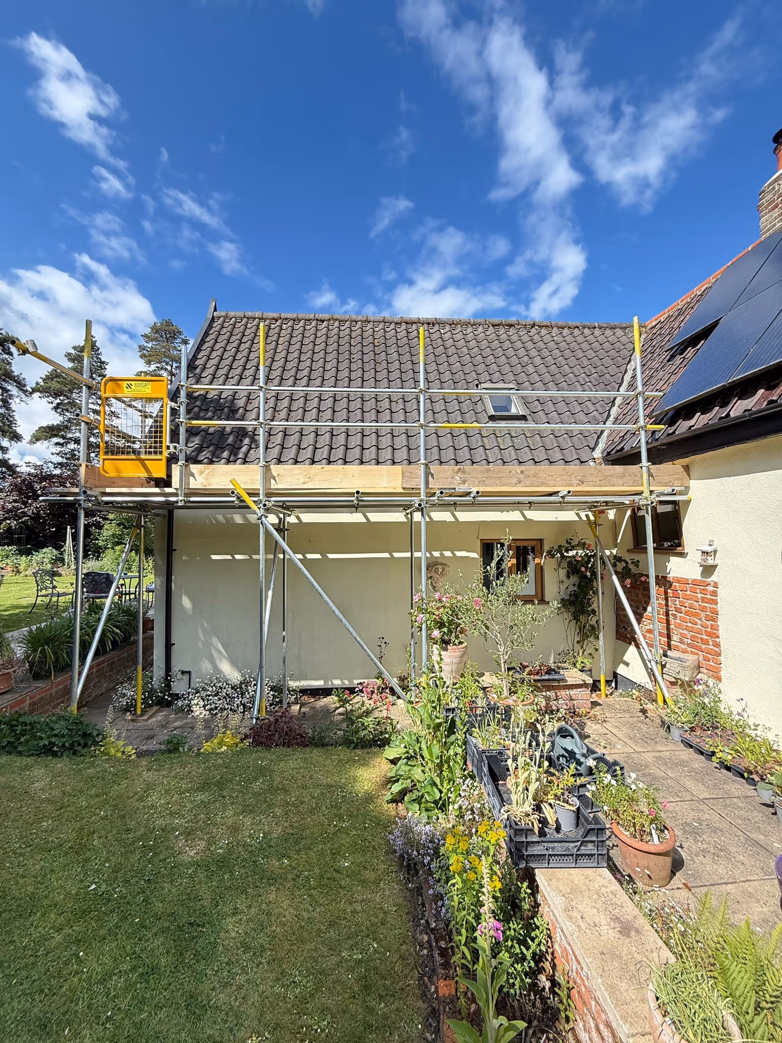 Scaffolding along the back of a bungalow for easy access to roof.