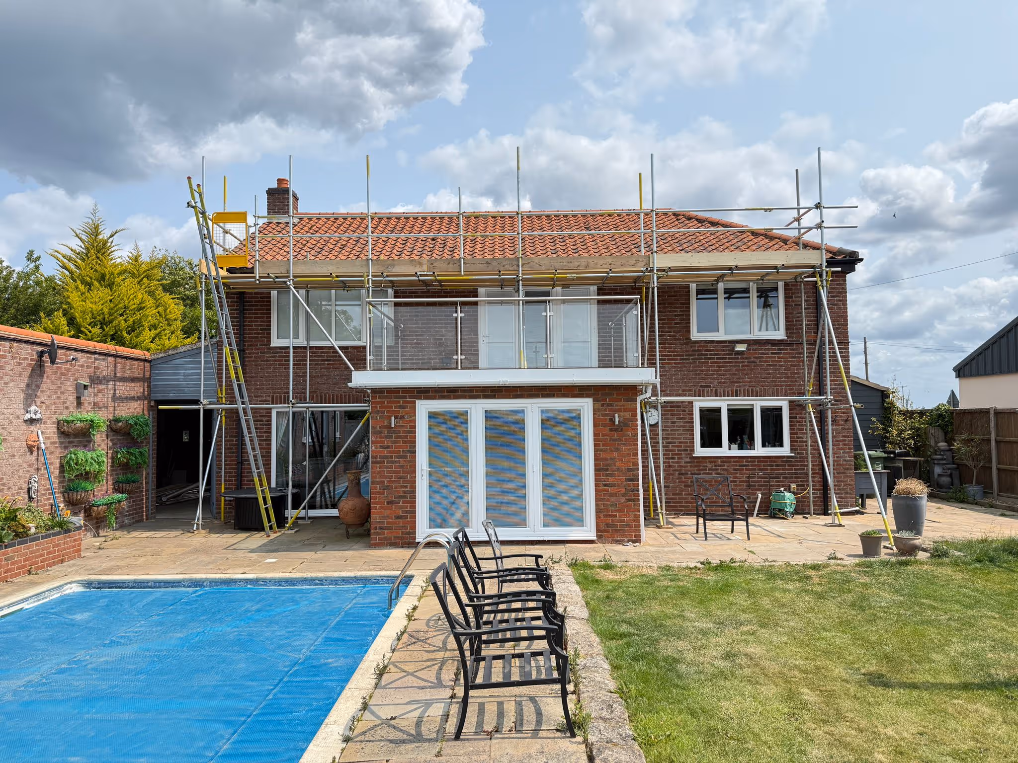 Worker standing on platform of scaffolding.