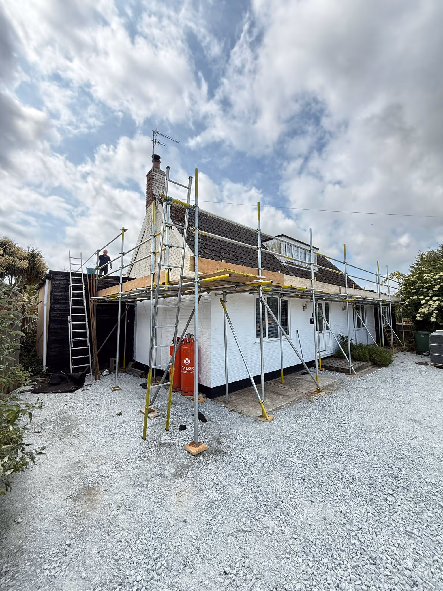 Worker standing on platform of scaffolding.