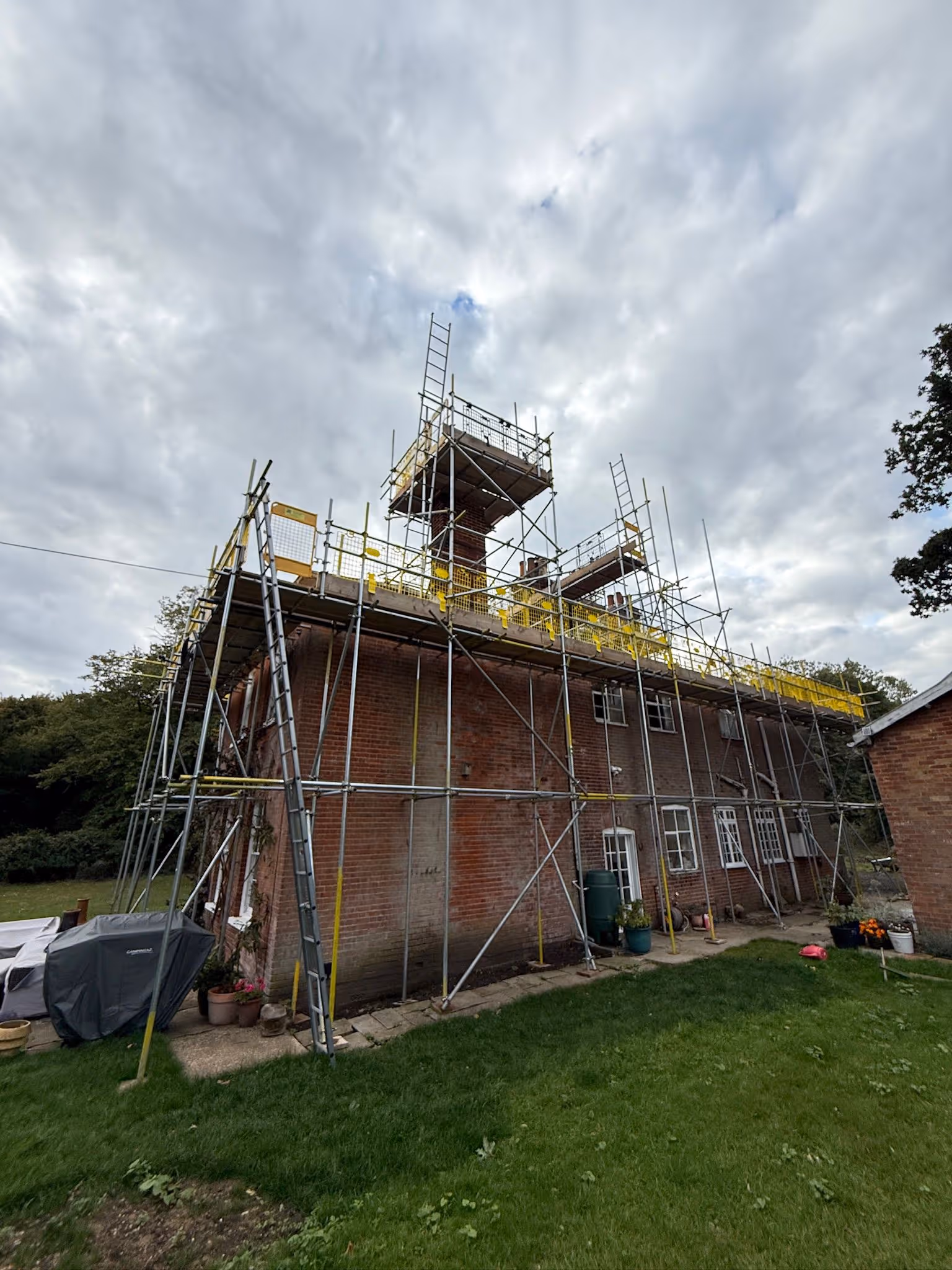 Scaffolding built around brick house.