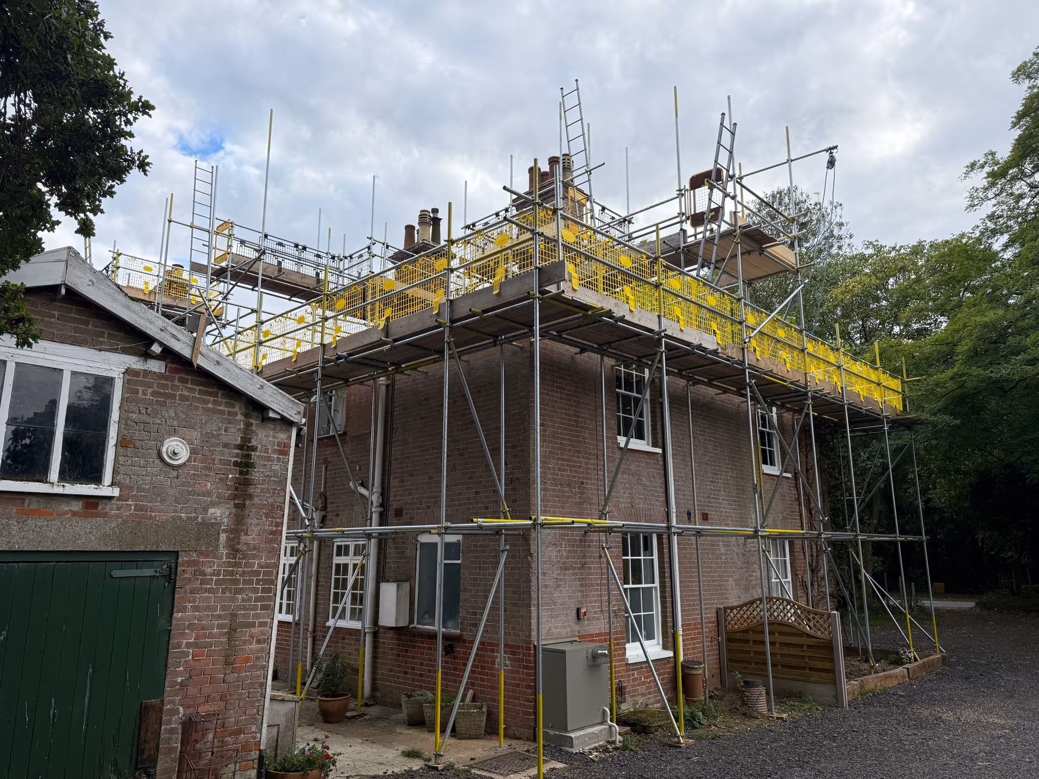 Worker standing on platform of scaffolding.