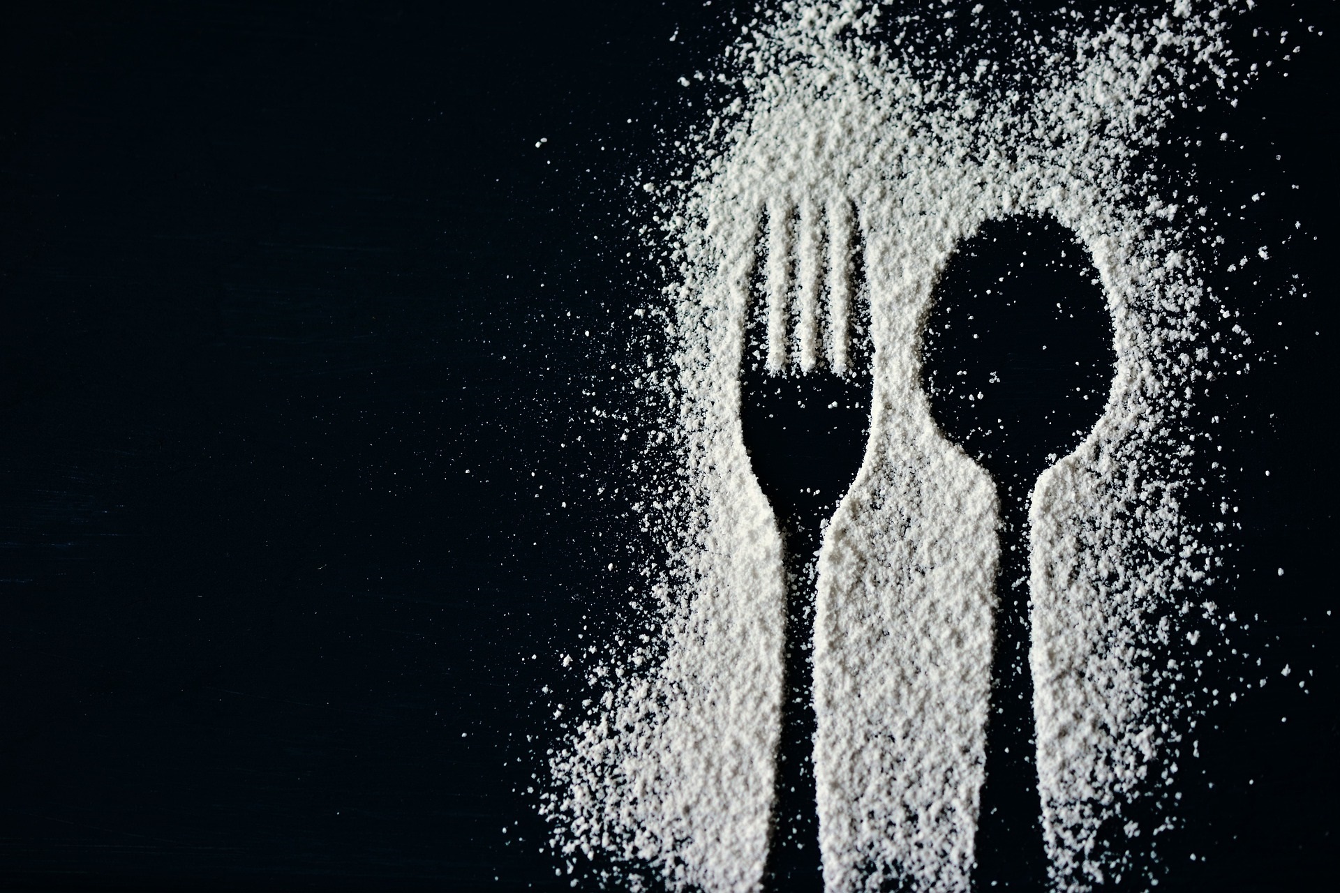 Mehl-Silhouette von Löffel und Gabel auf schwarzem Hintergrund – Symbolbild für Gastronomie-Datenmanagement mit GASTROPIM, der PIM-Lösung für die Gastronomiebranche.