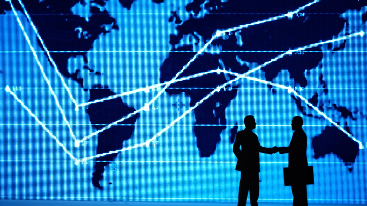 Technological world map lit up and silhouette of business people