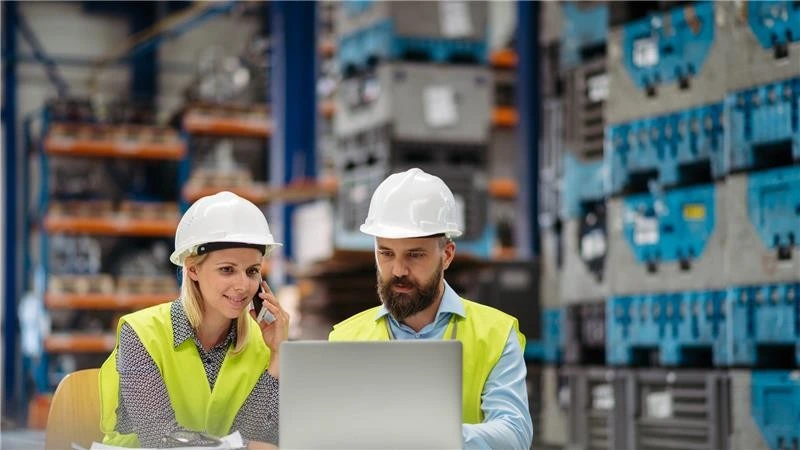 Manufacturing facility operators discuss financial planning and energy incentives in a warehouse