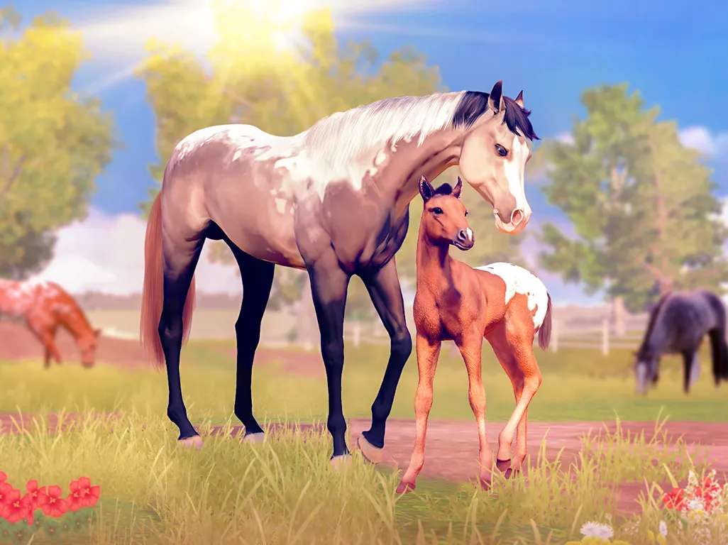 Light brown and white horse standing beside a foal in a grassy field with other horses and trees in the background under a bright sun.