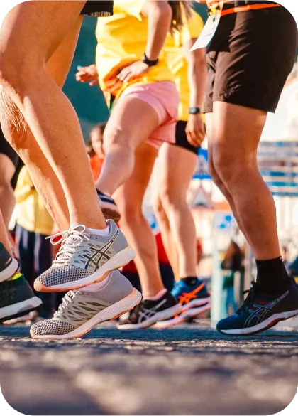 Close-up view of people participating in a race, wearing running shoes and athletic gear