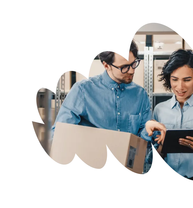 Two people in a warehouse reviewing a tablet