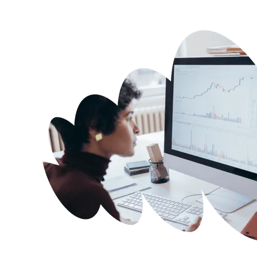 A woman closely observing a monitor displaying charts and graphs