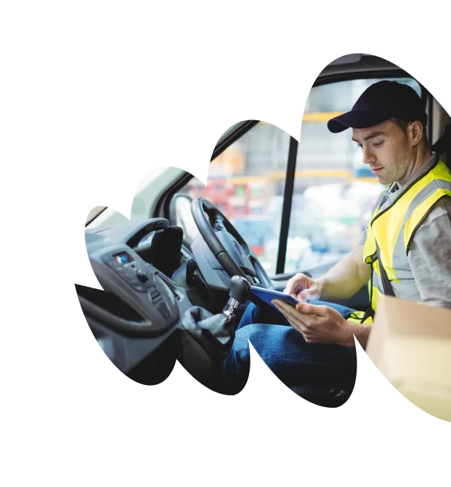 Delivery driver sitting in van, typing on tablet