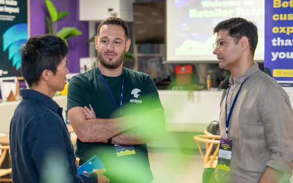 Three men are standing and conversing during an event