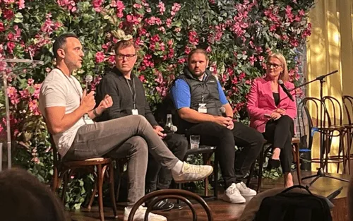 A panel of four speakers seated on chairs during a discussion event