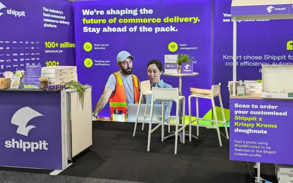 Shippit trade show booth with vibrant purple and green branding