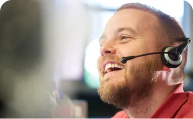A man wearing a headset and smiling.