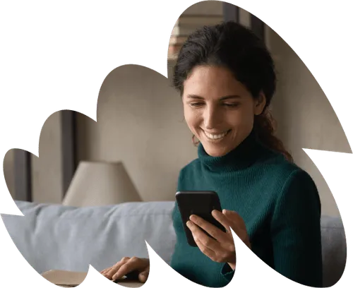 A woman sitting on a couch looking at a cell phone.