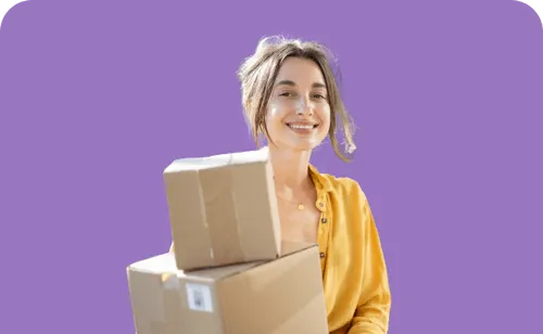A woman holding a stack of boxes in front of a purple background.