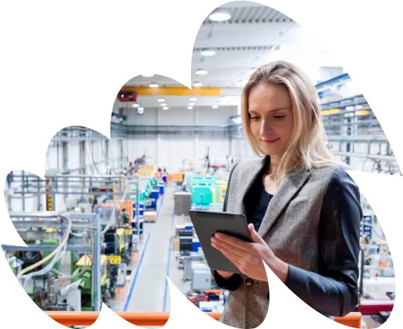 Businesswoman holding a tablet while standing in a large industrial facility