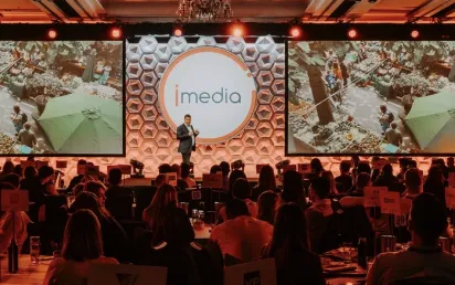 Speaker presenting on stage at an iMedia event