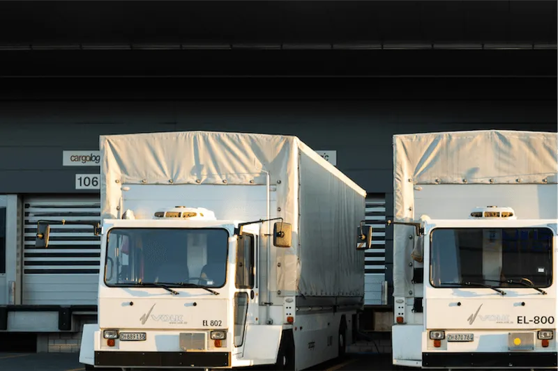 Two trucks outside shipping depot