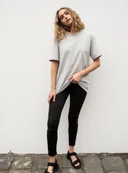 Woman wearing grey t-shirt and lack sandals