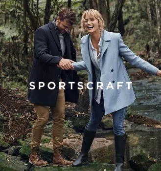 Man and woman crossing riverewearing coats