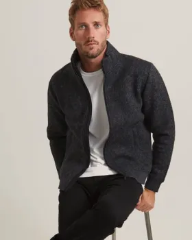 Man sitting on stool wearing jacket