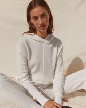 Woman sitting on floor wearing white hoodie