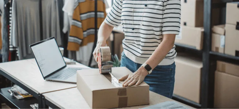 Lady taping a box for delivery