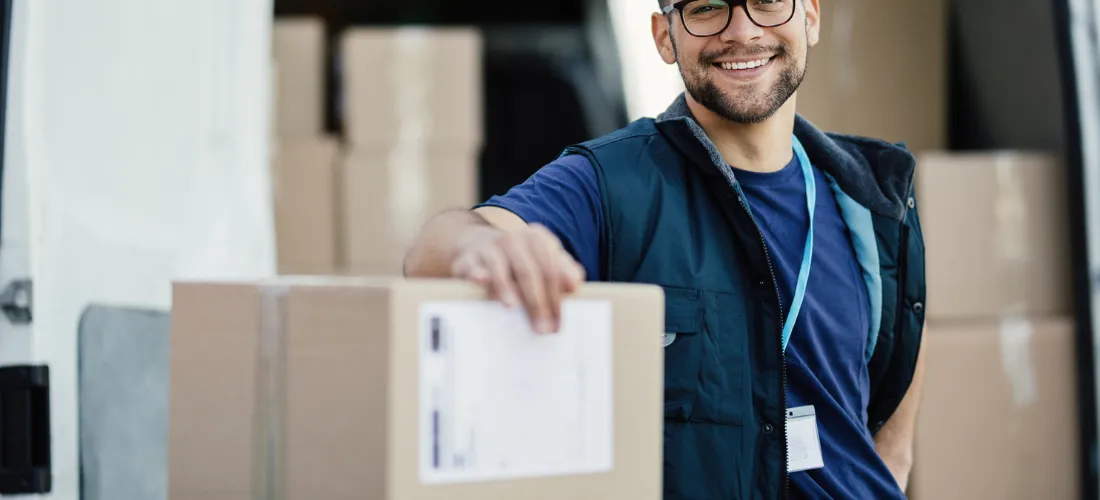 Delivery driver smiling holding a box