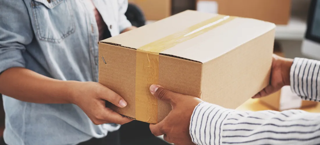 Person handing a sealed box to another person