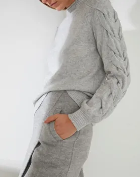 Woman in grey outfit with hand in pockets