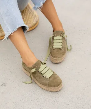 View of woman below knees wearing green shoes