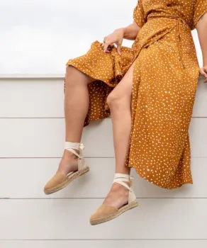 Woman stting on ledge in orange dress