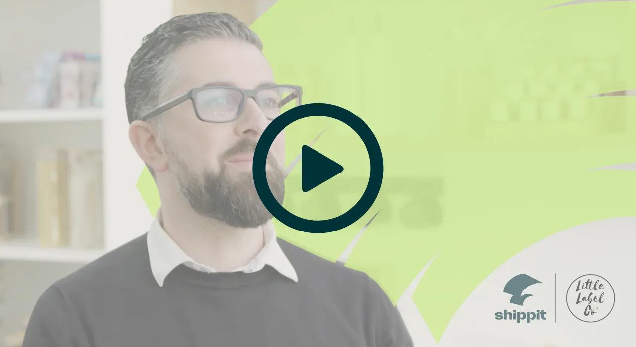 A video still showing a bearded man standing in front of a green wall, with the text "How Little Label Co. scaled with Shippit"