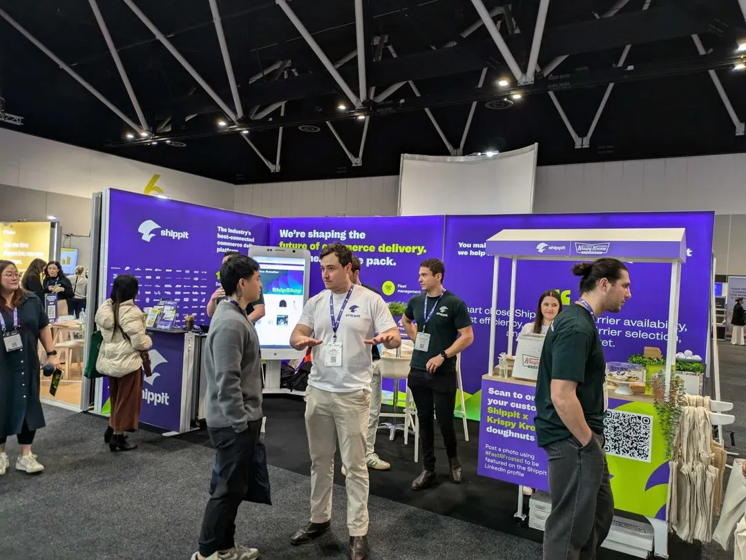 A busy exhibition booth for Shippit at a trade show with Shippit staff and attendees