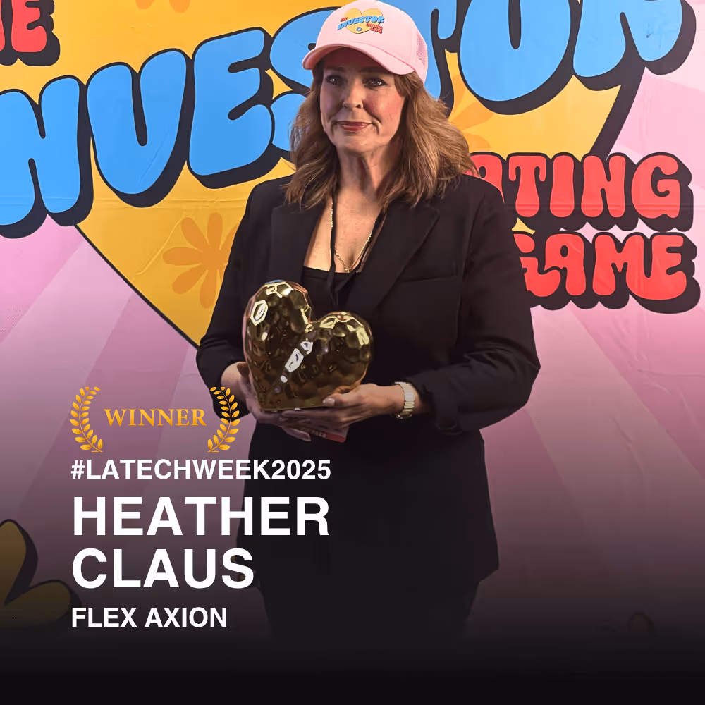 Heather Claus wearing a pink cap and black blazer holding a gold heart-shaped trophy in front of a colorful backdrop with text reading 'WINNER #LATECHWEEK2025 HEATHER CLAUS FLEX AXION.'