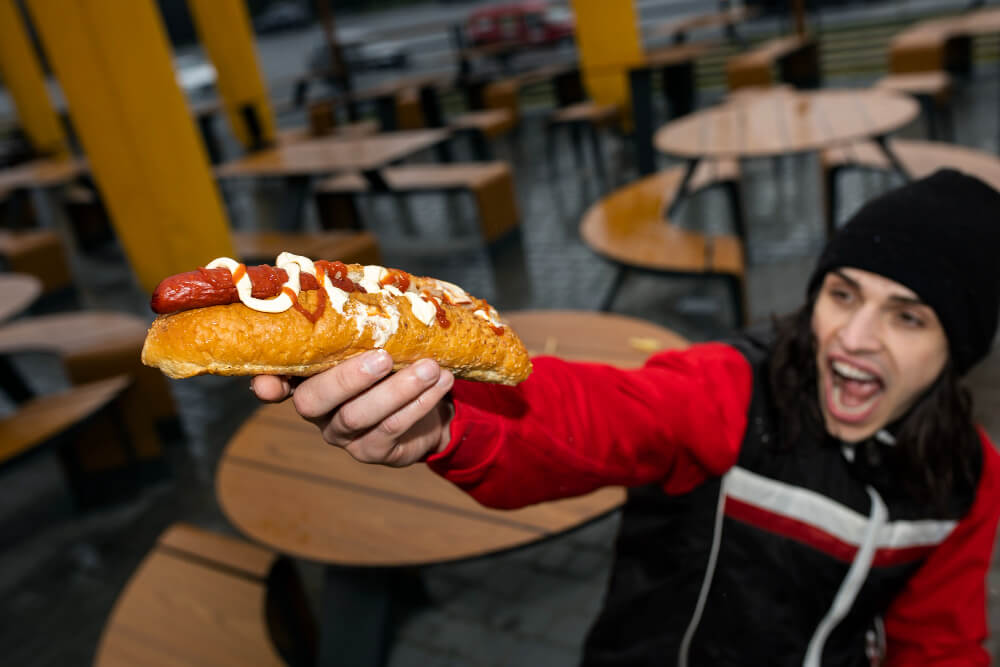 Person holding a hot dog in his hand.