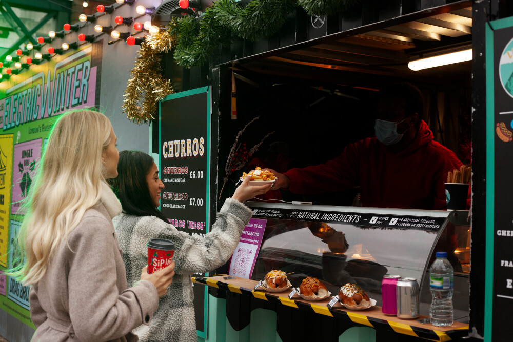 Person taking a take out food from a vendor in a take out truck.