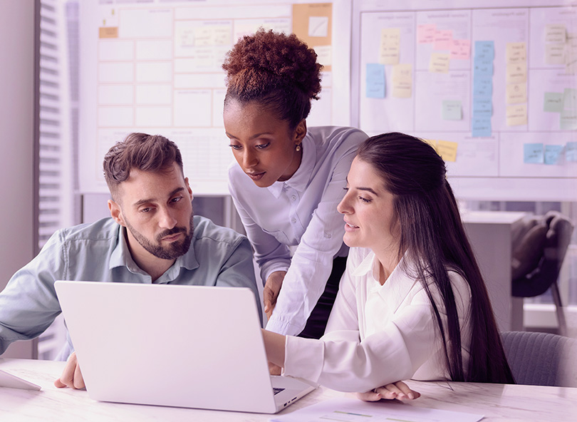 Business team reviewing data together in a modern office to inform competitive strategy decisions.