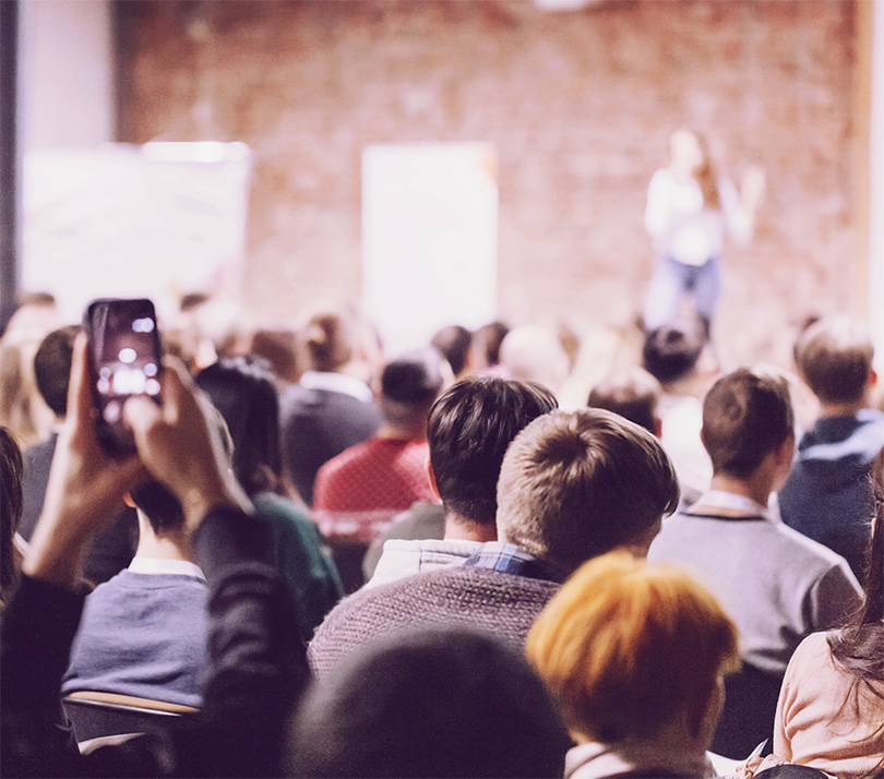 Audience listening to speaker in auditorium at a conference
