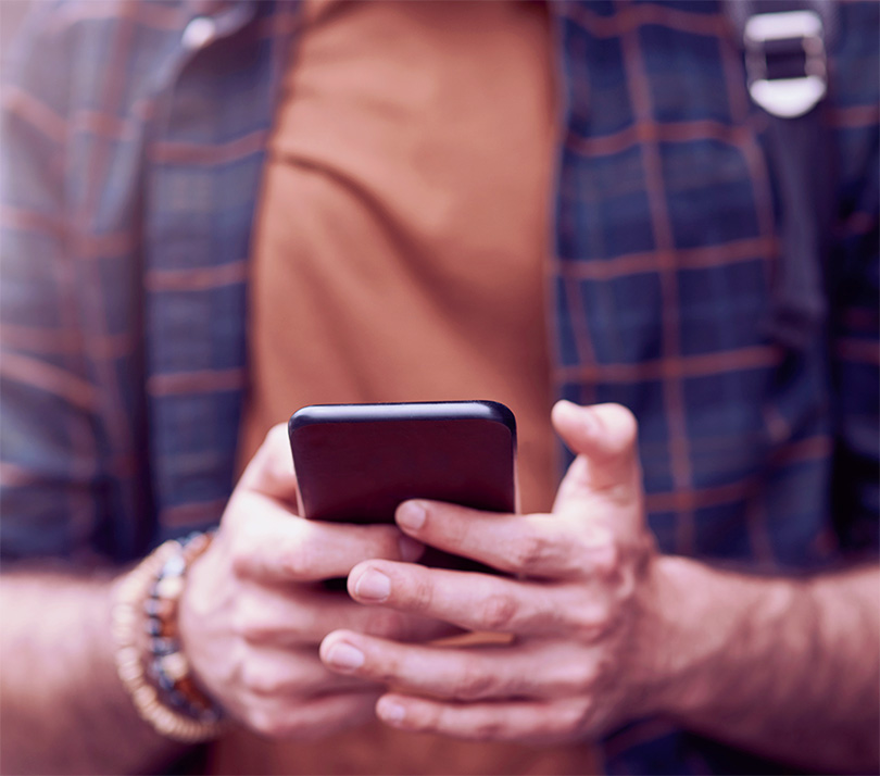 Close up of a man's hands using a mobile phone