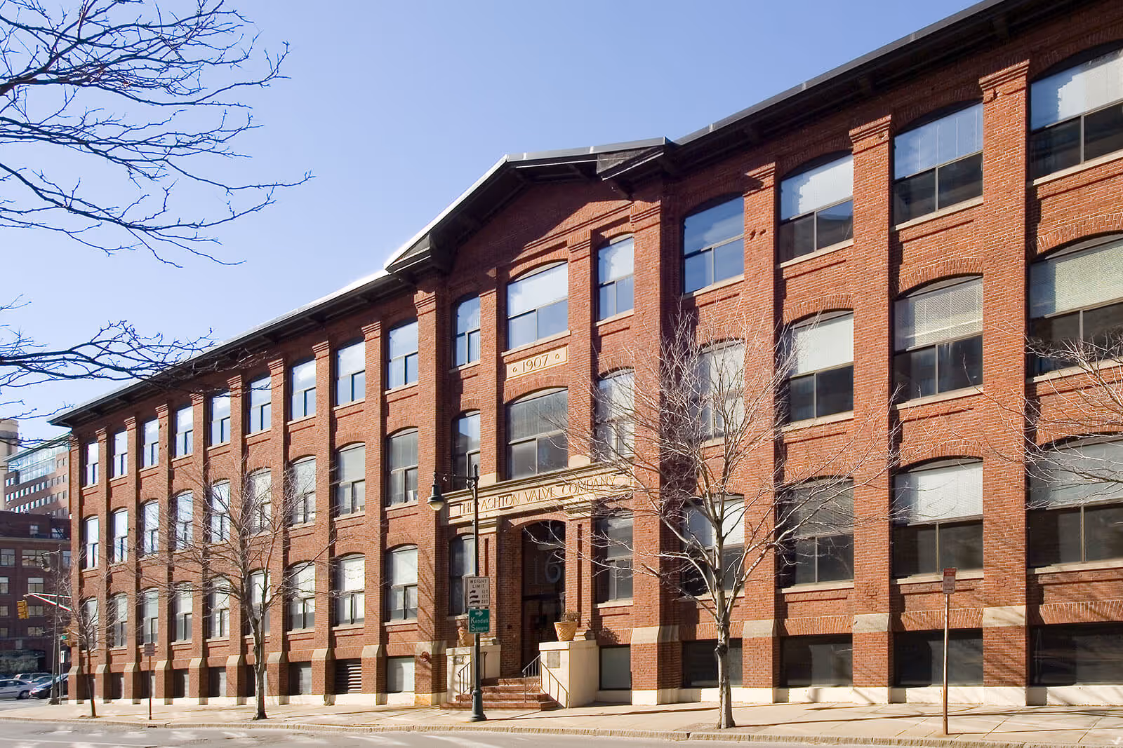 Historic red brick industrial building with large windows from 1907