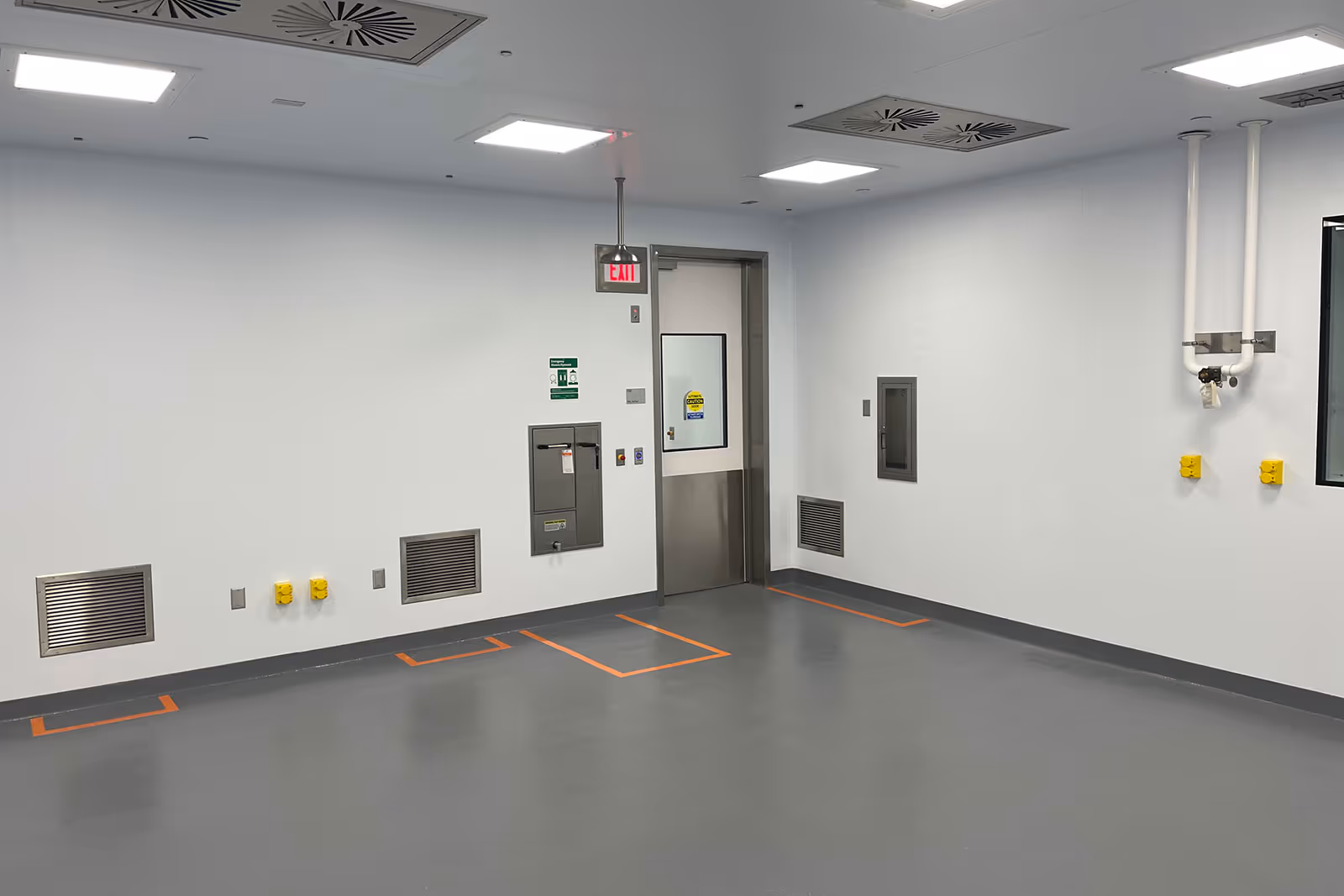 Clean, sterile industrial room with exit door and orange floor markings