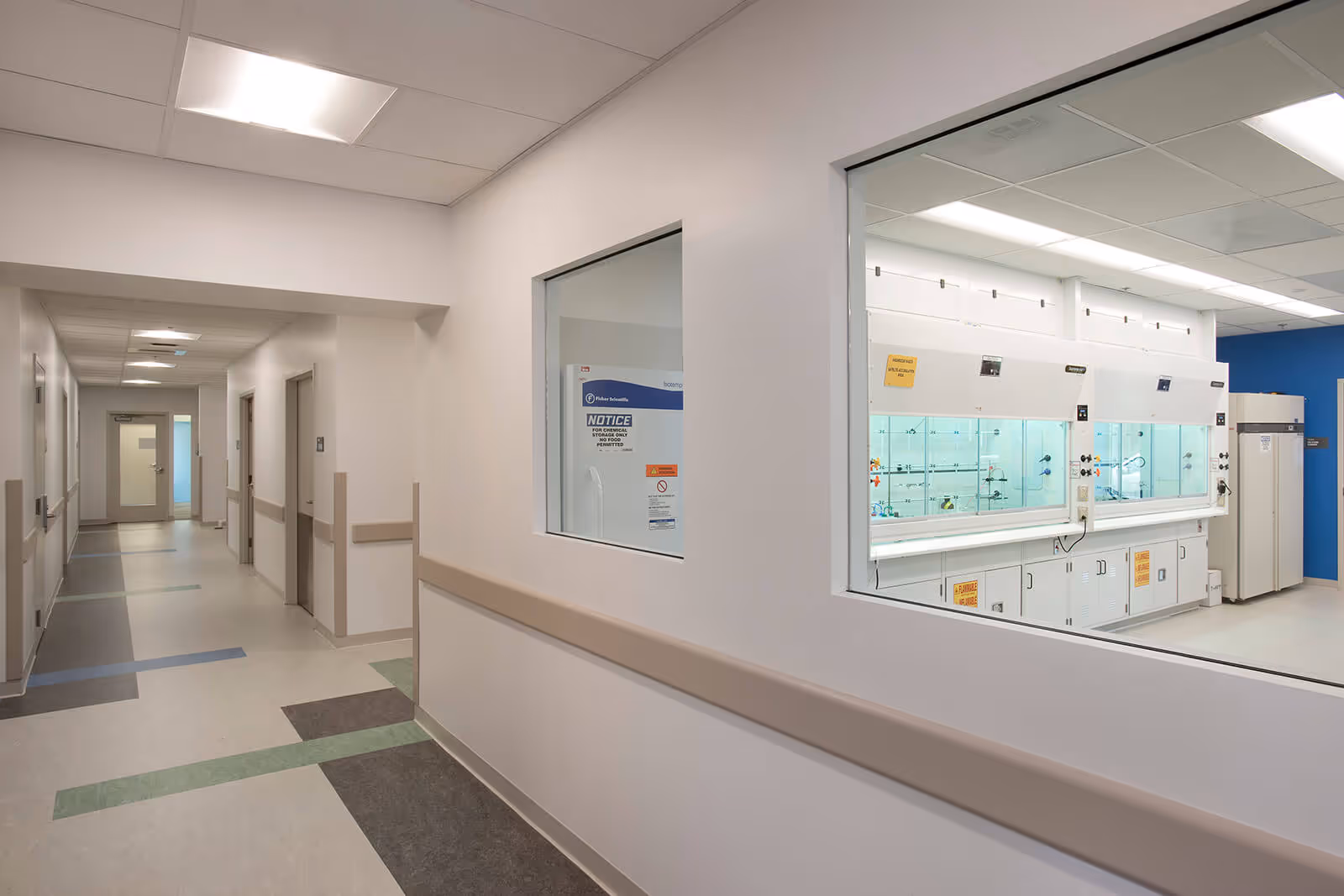 Clean, modern hospital corridor with laboratory window and clinical hallway